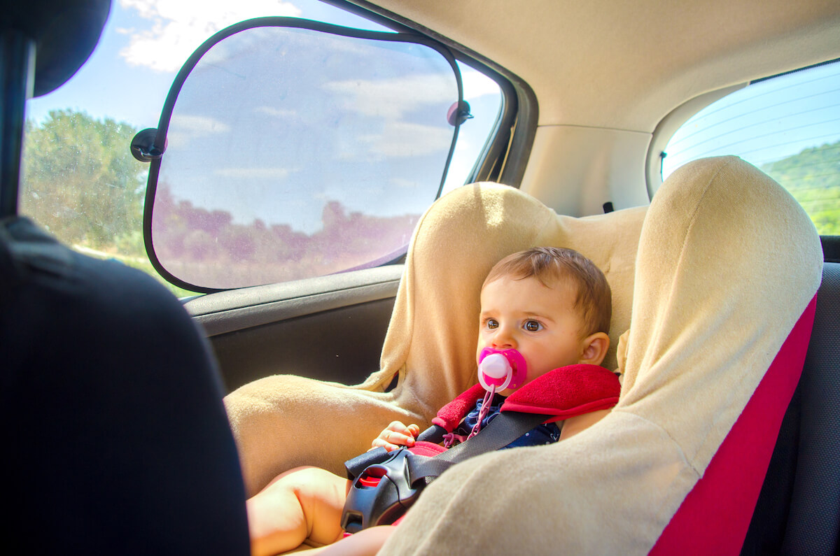 Ein Sonnenschutz mit Saugnäpfen für die Scheibe bewahrt das Kind im Auto vor zu viel Sonne. © iStock
