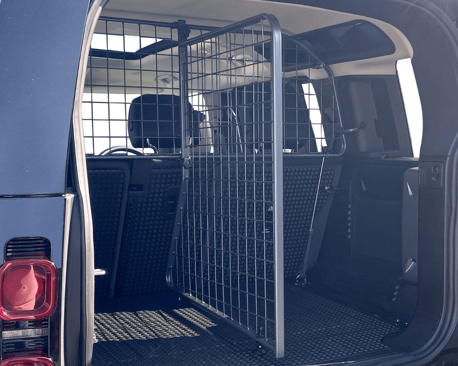 Ist im Kofferraum ein Hundegitter für Land Rover Defender nachgerüstet, wird der Hund ordnungsgemäß im Auto gesichert. Zusätzlich zum Hundegitter hat Travall ein Trenngitter in Längsrichtung sowie ein Heckgitter für Land Rover im Sortiment. © Travall