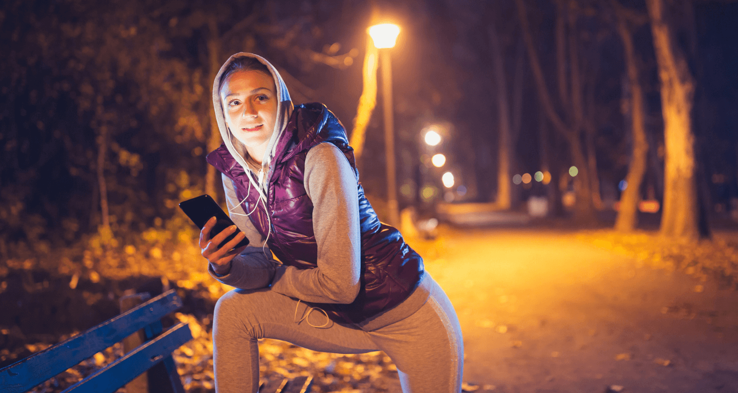 Eine Joggerin meldet sich zur Sicherheit bei ihrem Partner, wenn sie im Herbst joggen geht und es dunkel ist. © iStock.com