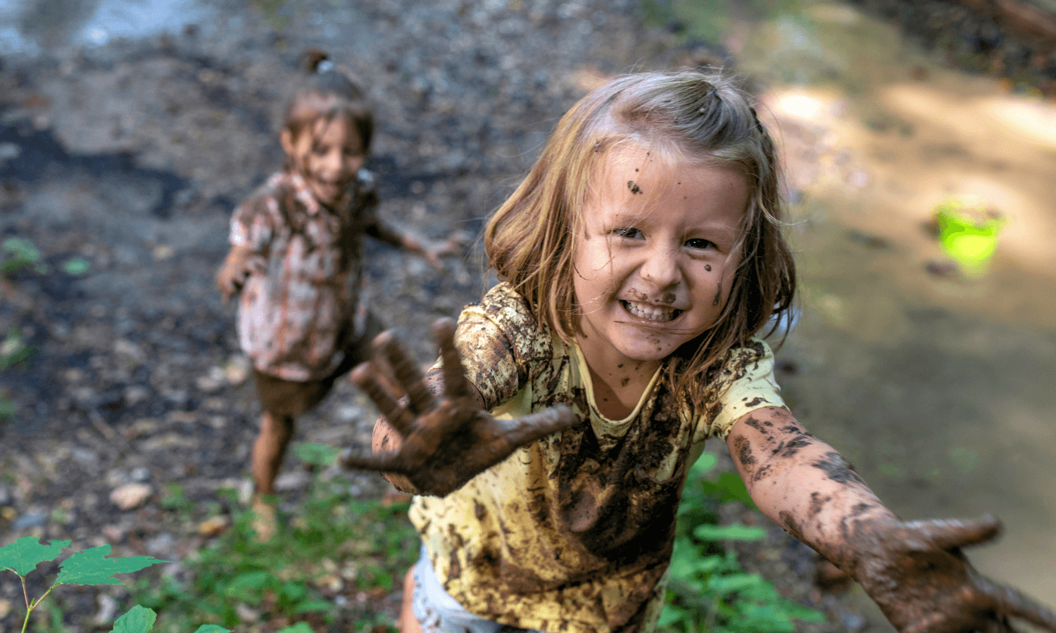 Zwei kleine Mädchen haben sich beim Spielen im Wald schmutzig gemacht. © iStock.com