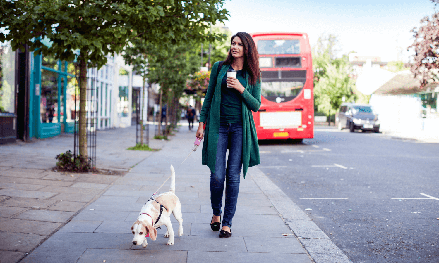 Ein Frau geht mit ihrem Hund in London, Großbritannien, spazieren. Im Hintergrund ist ein roter Bus zu sehen. © iStock.com