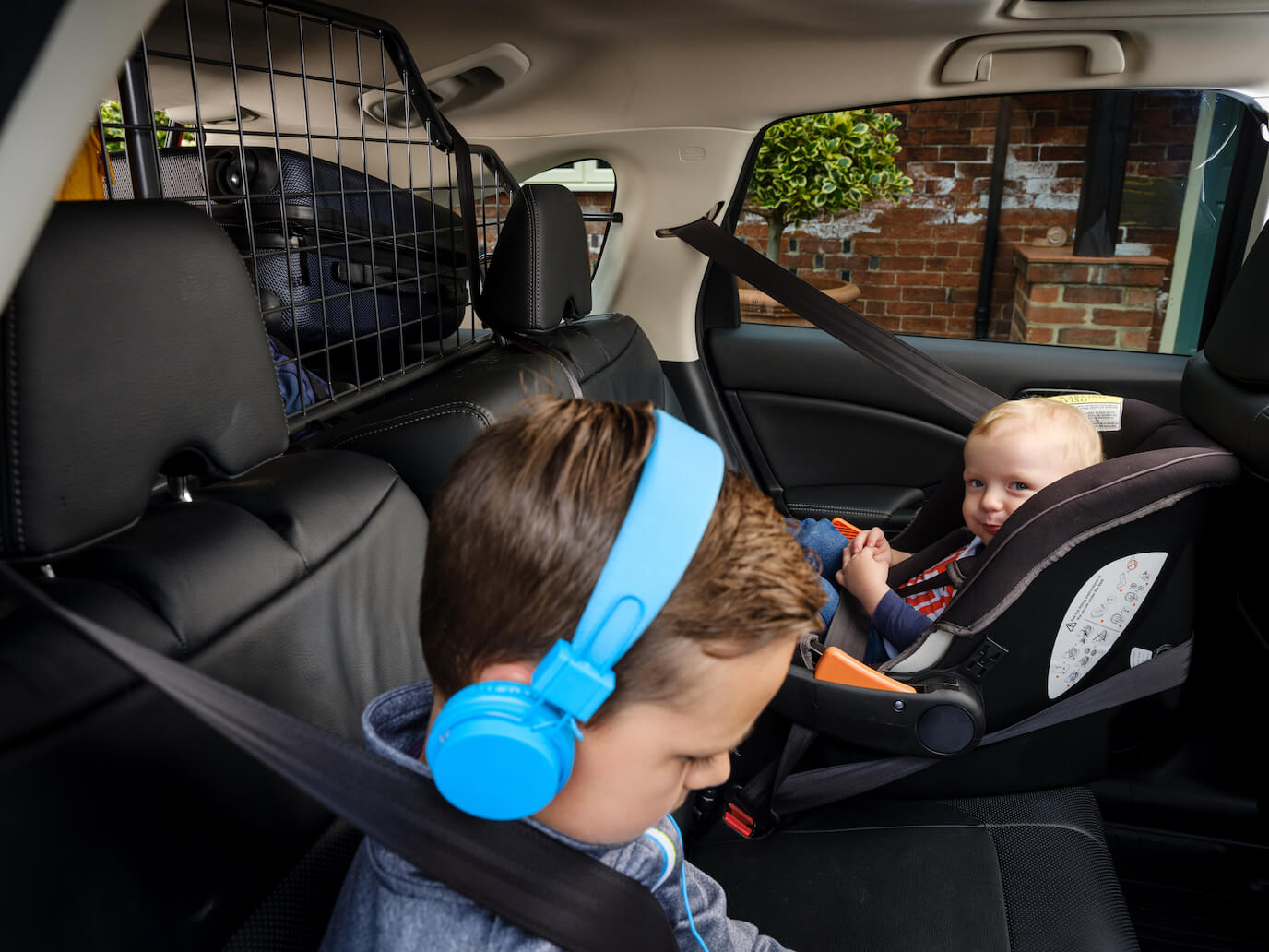 Children in car with Travall vehicle-specific dog guard installed