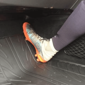 Football boot in car with rubber mat to protect UK sport