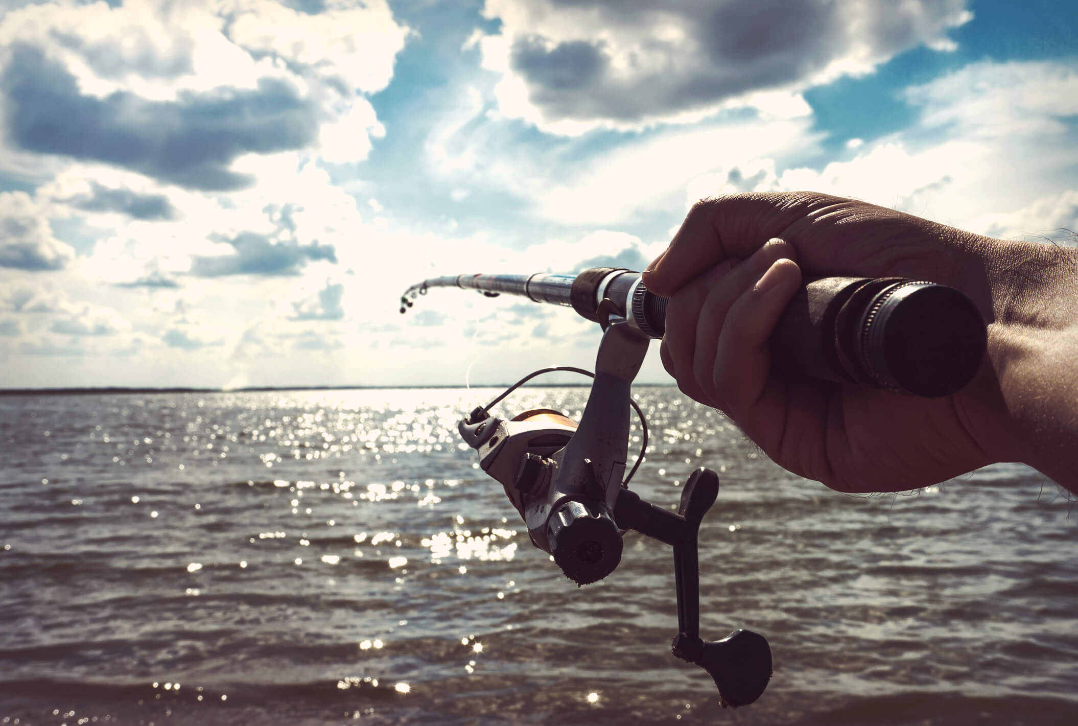 the hand of the fisherman holding the rod